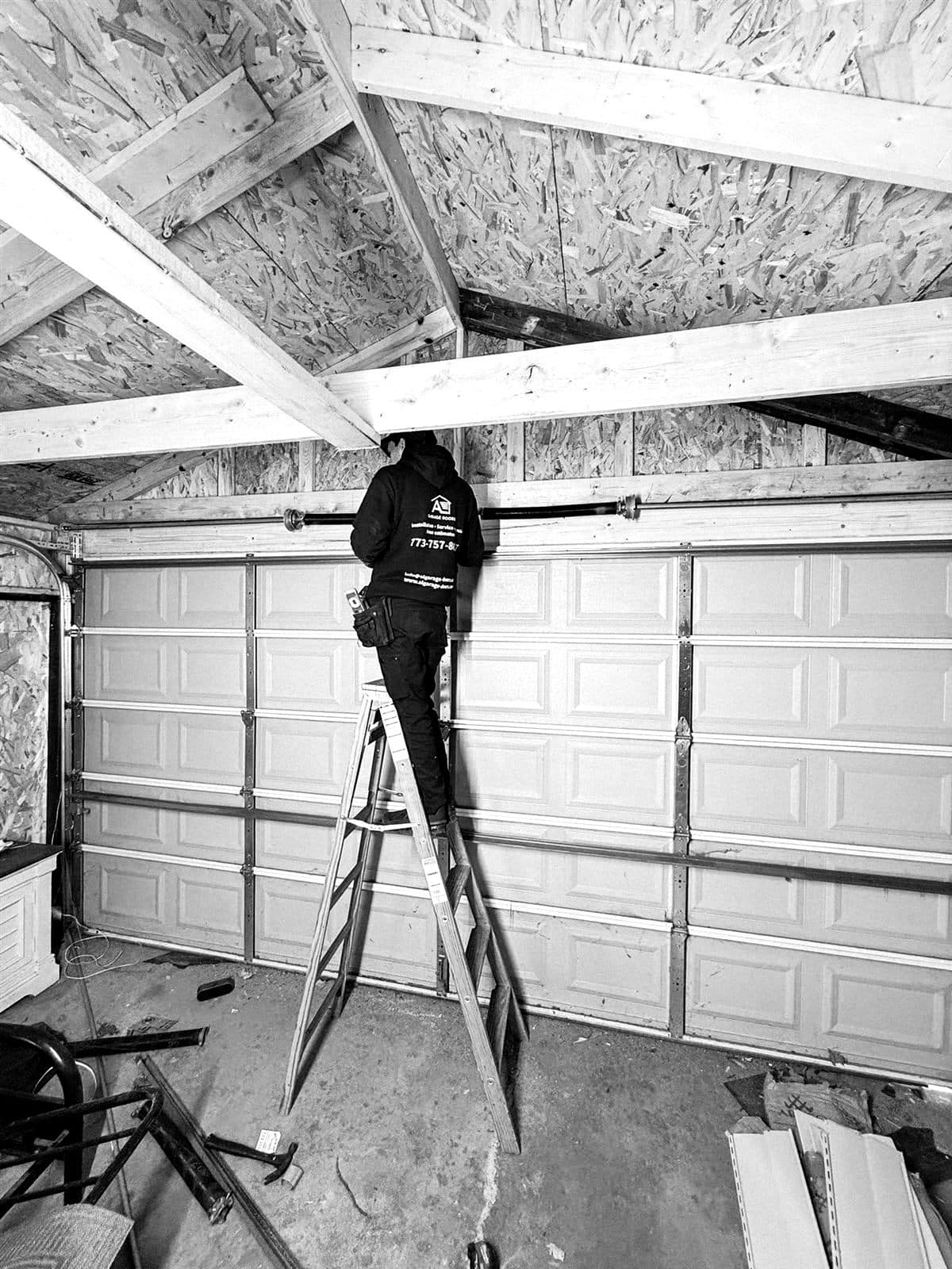 AL Garage Doors technician working on a garage door torsion spring