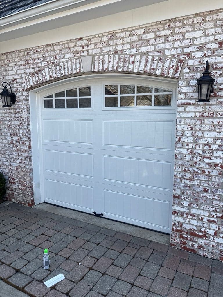 White carriage-style garage door with arched windows